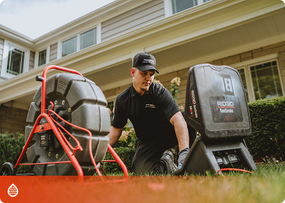 Precision-Drains-CTA Precision Today technician operating a drain-cleaning machine outside a home