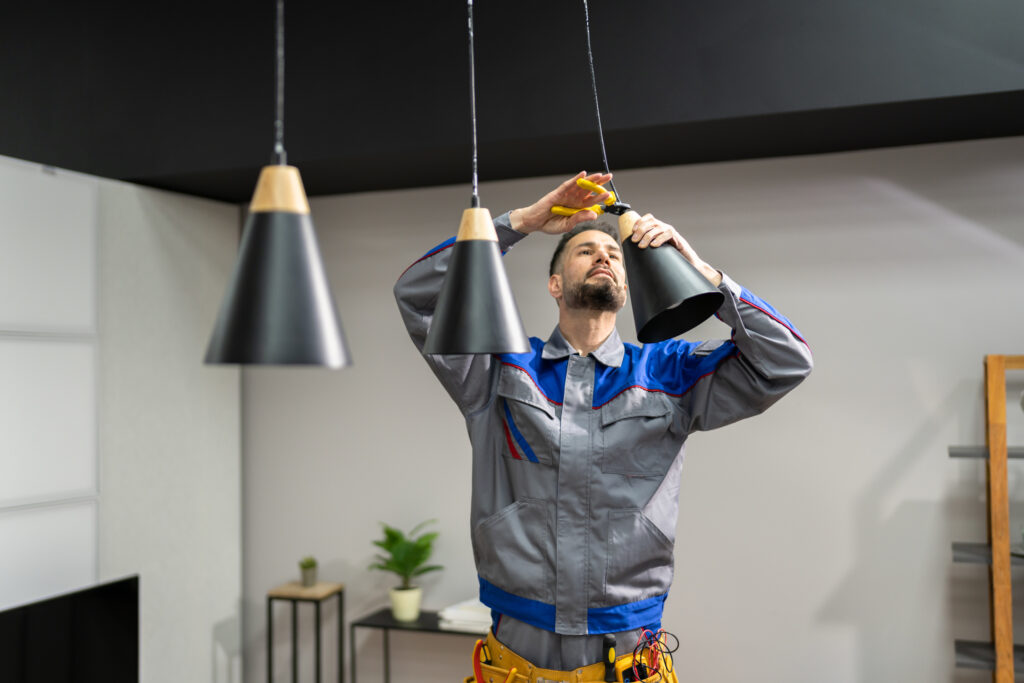 Electrician installing pendant lights in a kitchen.