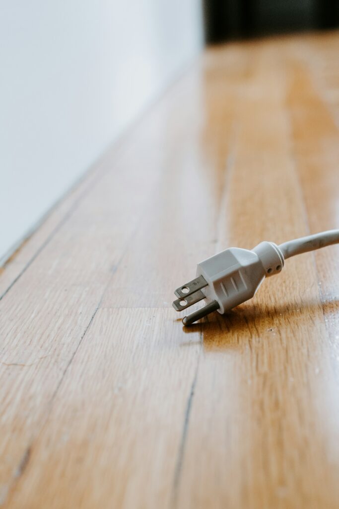 Power cord laying on wood floor.
